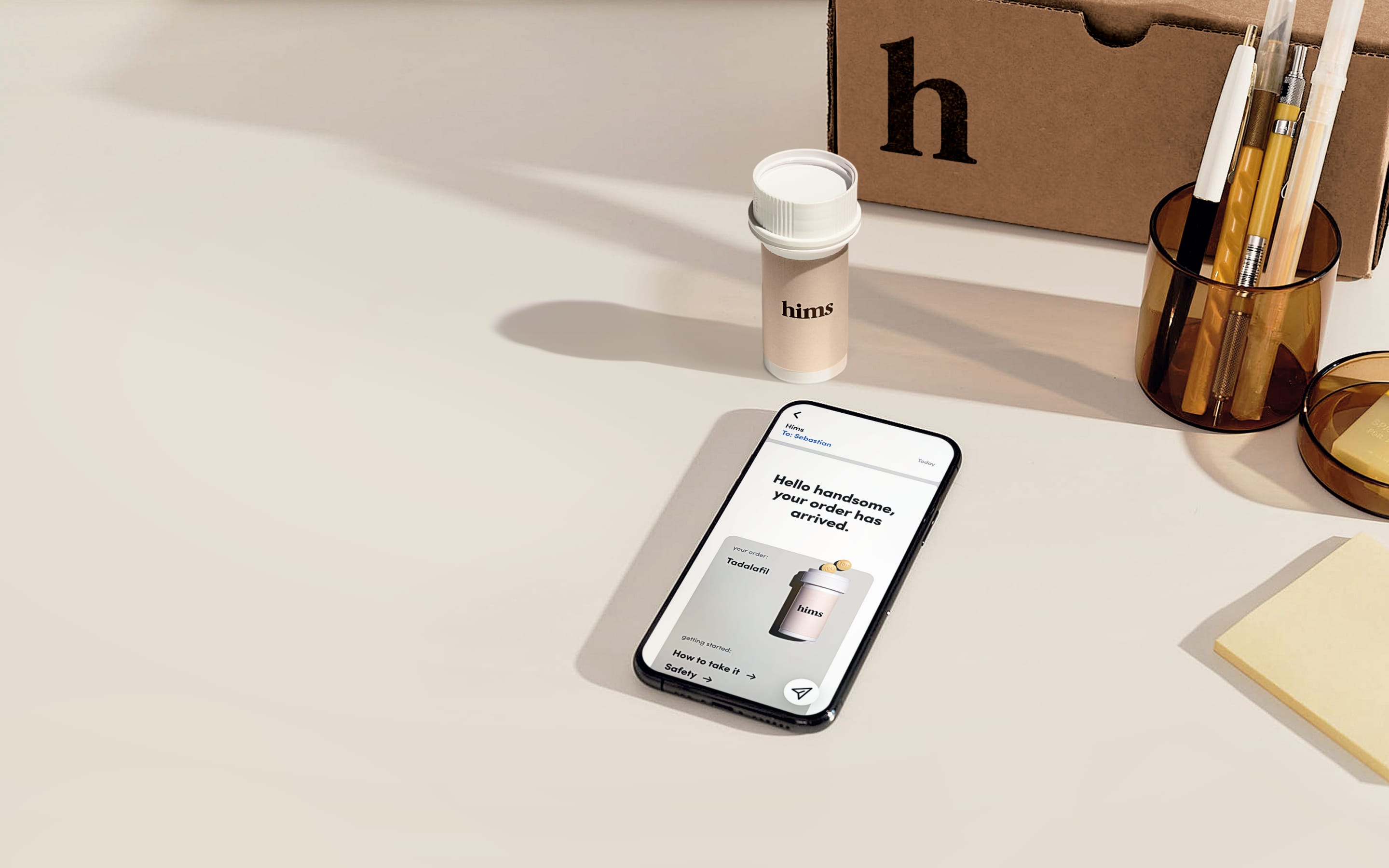 bottle of pills with a phone on a desk